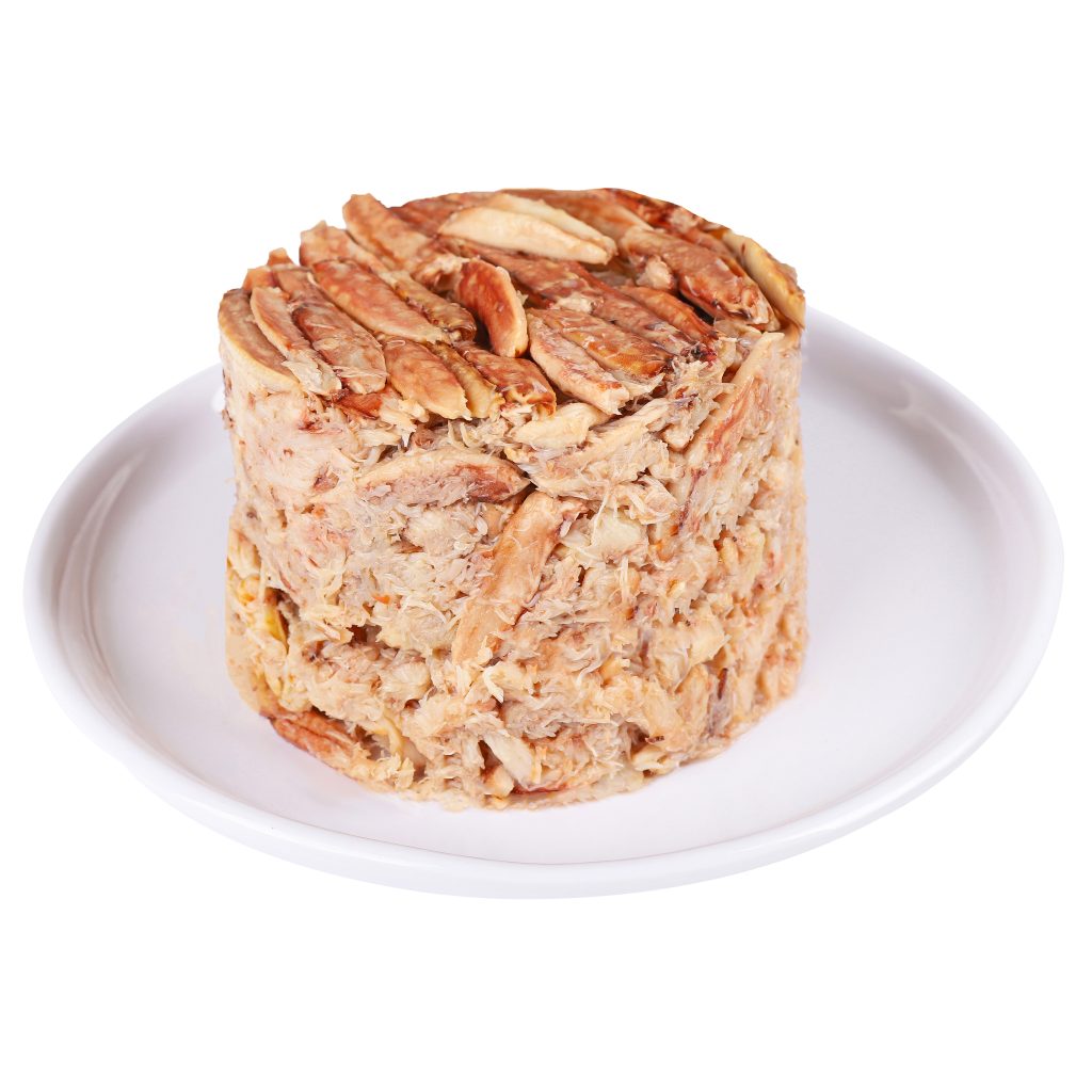 Canned tuna shaped in a cylinder on a white plate, isolated on a white background.