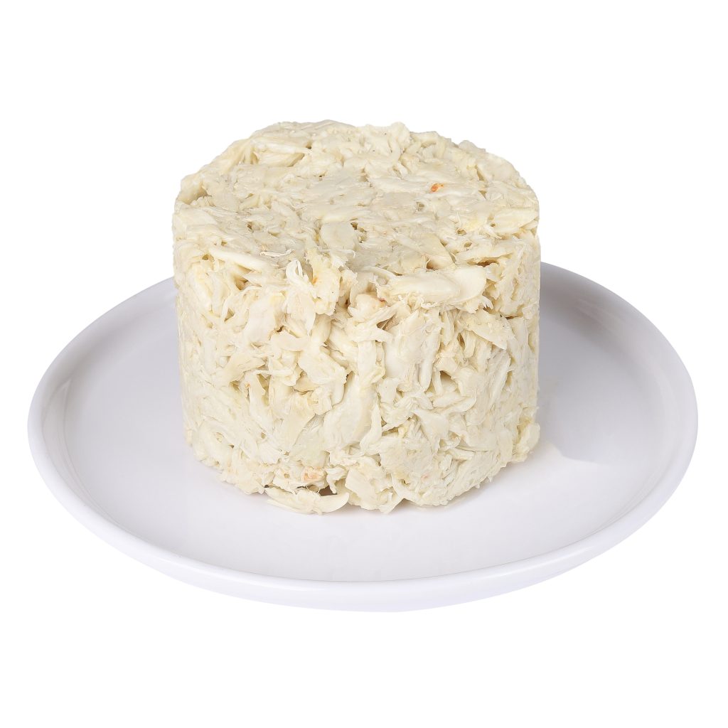 A round mound of lump crab meat on a white plate, isolated on a white background.